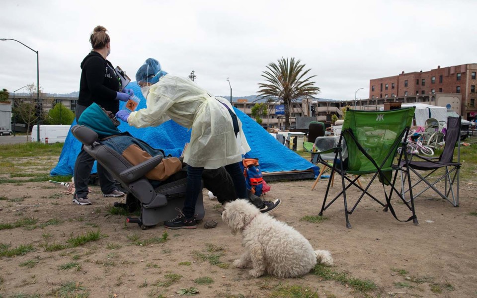 Image of nurse administering COVID-19 test at a homeless encampment